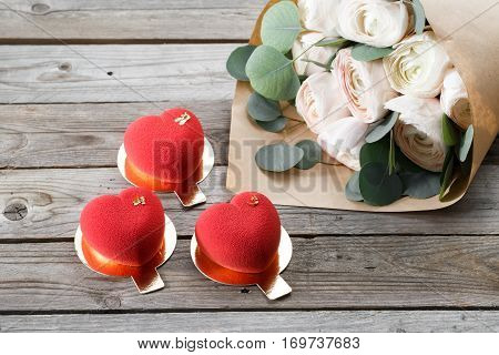 Red heart cacke desserts and buttercups on wooden background. dessert for breakfast on Valentine's Day.