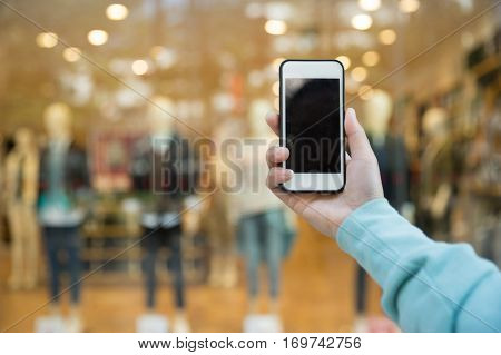 hands use smartphone taking photo front of shopwindow