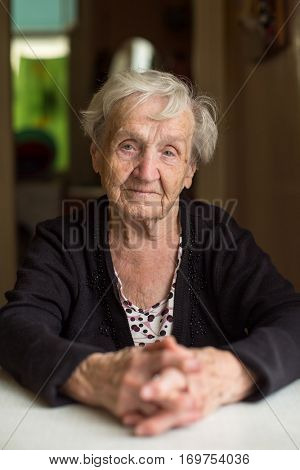 Portrait of an old woman 85 years old, in the kitchen.