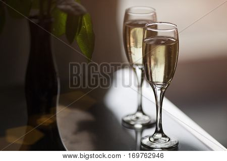 Two glasses of champagne on a glass table