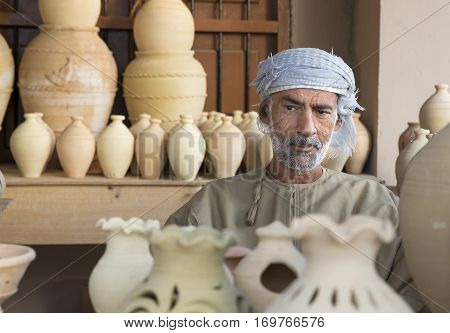 Muscat Oman February 4th 2017: omani man selling clay jars