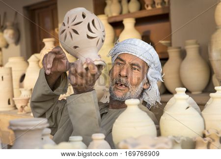 Muscat Oman February 4th 2017: omani man selling clay jars