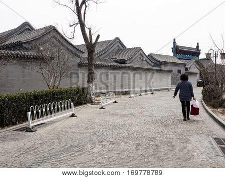 Beijing, China - March 8, 2015: Woman Walking Down The Street In Historic Hutong District Of Beijing