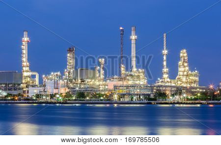 Scenic of oil refinery plant of Petrochemistry industry in twilight time and reflection in near river in Bangkok Thailand.