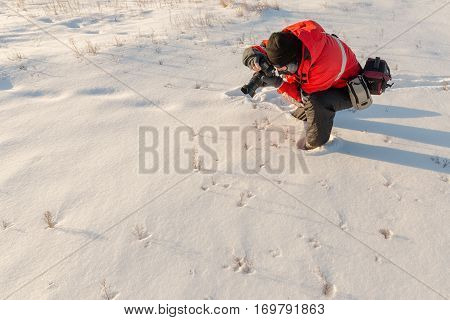 photographer takes winter landscape at dawn in the bitter cold.