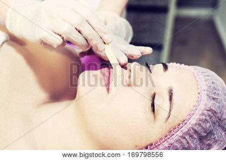 Depilation With Hot Wax Mustache In The Beauty Salon. Young Woman Receiving Facial Epilation Close U