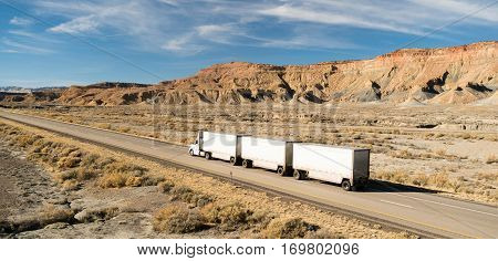 A Semi Truck carrying three tandem trailers over the road