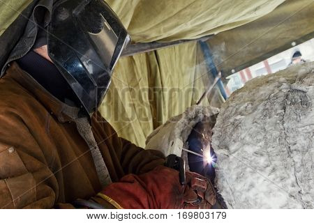 Manual arc welding chromemolybdenum pipe with concomitant heating