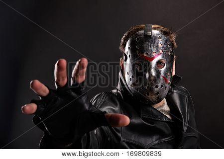 Maniac in hockey mask on dark background