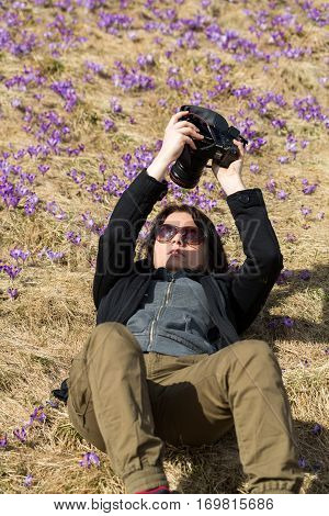 CHOCHOLOWSKA VALLEY, POLAND - MARZ 31, 2016|: Attractive woman taking selfie against the background of flourishing crocuses. Chocholowska Valley Poland
