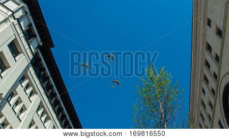 three aircraft fly over the city on a background of blue sky