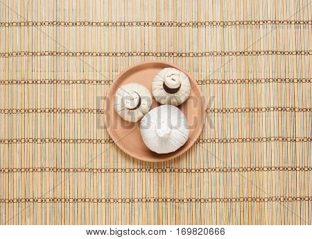 Massage bundles on a plate on bamboo mat. Spa, health, treatment, concept. 
