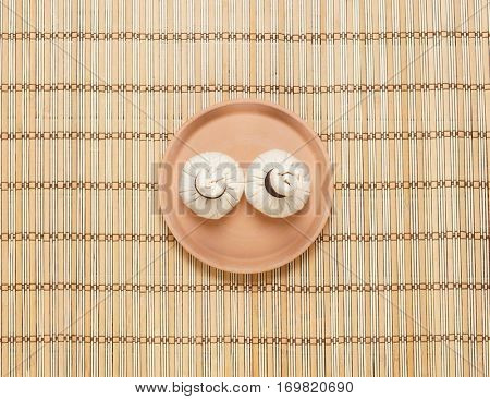Massage bundles on a plate on bamboo mat. Spa, health, treatment, concept. 