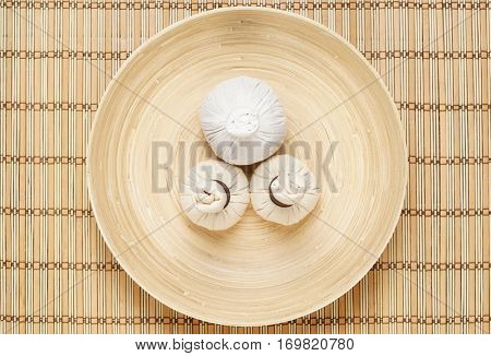 Massage bundles on a plate on bamboo mat. Spa, health, treatment, concept. 