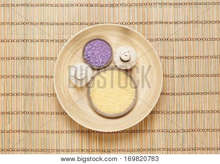 Massage bundle on a plate with bath salt over bamboo mat. Spa, health, treatment concept.