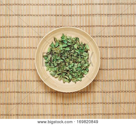 Plate with aroma petals on bamboo mat. Spa, beauty, treatment concept. 