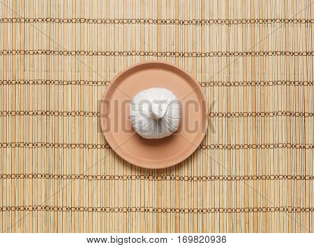 Massage bundle on a plate on bamboo mat. Spa, health, treatment, concept. 