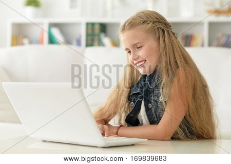 Portrait of a cute little girl using laptop