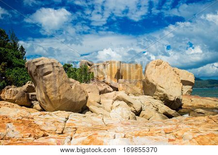 Landscapes on Hon Do island in the sea near Nha Trang city, Vietnam. Clouds, sky and orange rocks. Vibrant horizontal image