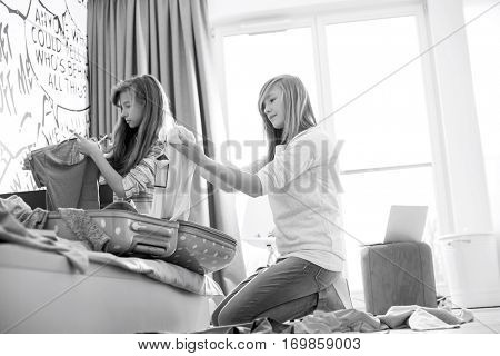 Sisters cleaning bedroom