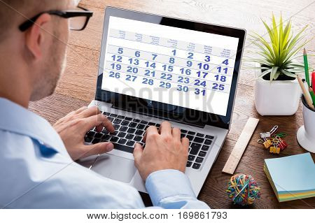 Close-up Of A Business Person Looking At Calendar With Daily Agenda On Laptop Computer
