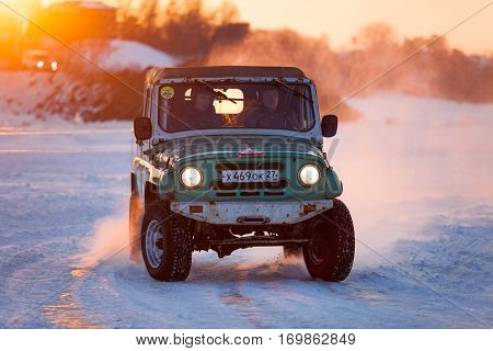 KHABAROVSK RUSSIA - JANUARY 28 2017: Russian UAZ 469 moving on ice of a frosn river at sunset