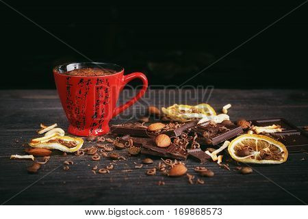 Chocolates background. Chocolate. Cup of hot chocolate lemon nuts and assortment of fine chocolates in dark and milk chocolate on dark wooden table
