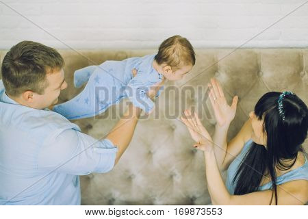happy family consisting of mom and dad's baby boy. happy family relationships. father holding the baby in his arms. child flies