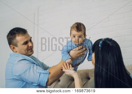 happy family consisting of mom and dad's baby boy. happy family relationships. father holding the baby in his arms. child flies