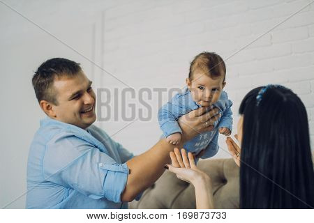 happy family consisting of mom and dad's baby boy. happy family relationships. father holding the baby in his arms. child flies