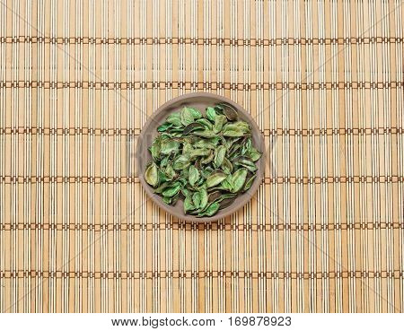 Plate with aroma petals on bamboo mat. Spa, beauty, treatment concept. 