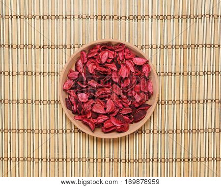 Plate with aroma petals on bamboo mat. Spa, beauty, treatment concept. 