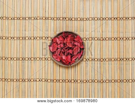 Plate with aroma petals on bamboo mat. Spa, beauty, treatment concept. 