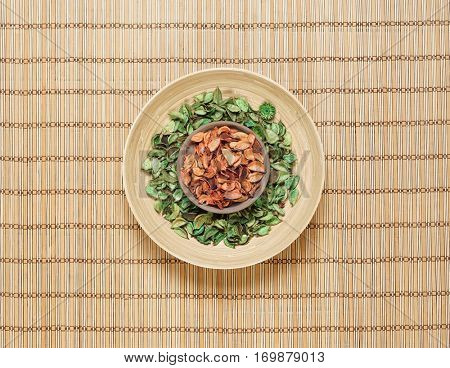 Plate with aroma petals on bamboo mat. Spa, beauty, treatment concept. 