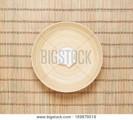 Seashell on a plate over bamboo mat. Health, spa, treatment concept.