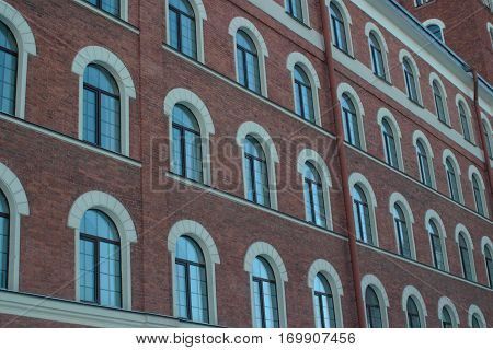 The background is an old brick building with many windows