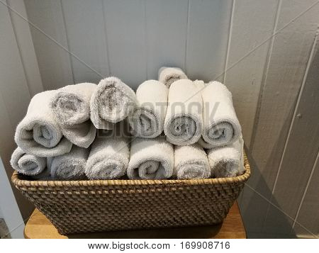 pile of cloth hand towel table napkin handkerchief on the basket with blur white wooden wall background