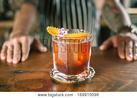 Closeup barman is making cocktail at night club. Negroni cocktail