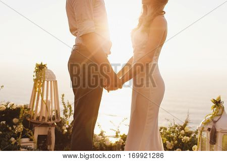 The bride and groom on the background of the Ocean during sunset