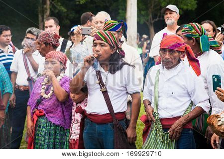 TIKAL, GUATEMALA - DEC 21, 2015: Unidentified Mayan people and tourists surround a fire on December 21, 2015  in Tikal, Guatemala. Traditional Mayan fire ceremony at the 2015 new year celebrations.