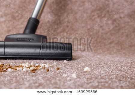 Vacuuming carpet with vacuum cleaner. Dirt on the rug. Housework service. Close up of the head of a sweeper cleaning device.