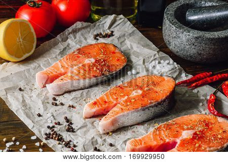 Raw Red Fish and Some Spices on Parchment Paper