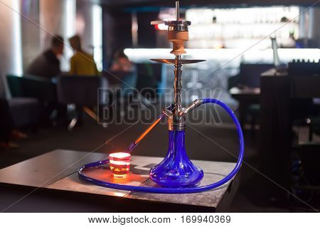 Close-up photo of blue hookah with tube.