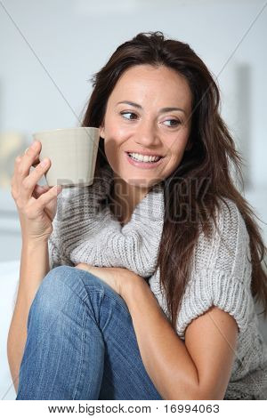 Closeup of beautiful woman with hot drink at home