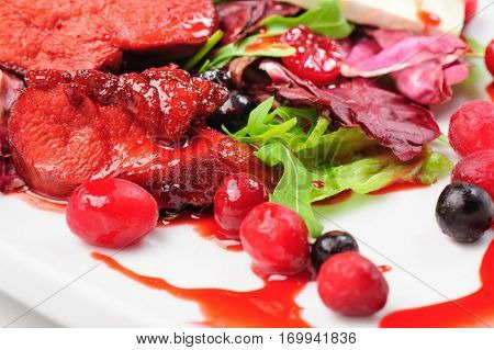 Salad with roasted duck fillet, berry sauce, cheese and fresh herbs