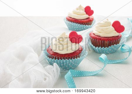 Red velvet heart cupcakes with cream cheese frosting and a red heart for Valentine's Day