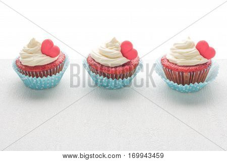 Red velvet heart cupcakes with cream cheese frosting and a red heart for Valentine's Day