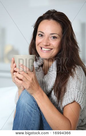Closeup of beautiful woman with hot drink at home