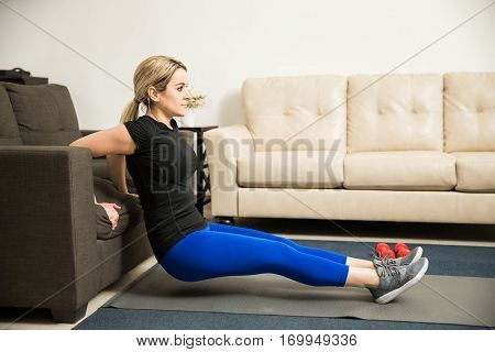 Woman Doing Tricep Dips On A Couch At Home