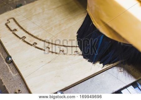 Big machine carves the wood of the curly pieces of plywood closeup.
